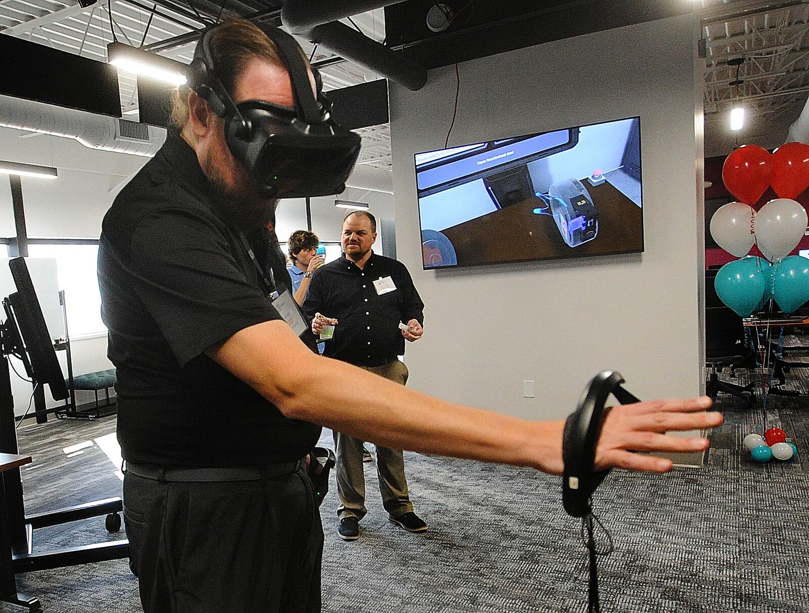 Josh Latham, demonstrates virtual reality training at the new University of Dayton Research Institute, Digital Transformation Center (DTC) Wednesday, Nov. 8, 2023. MARSHALL GORBY\STAFF