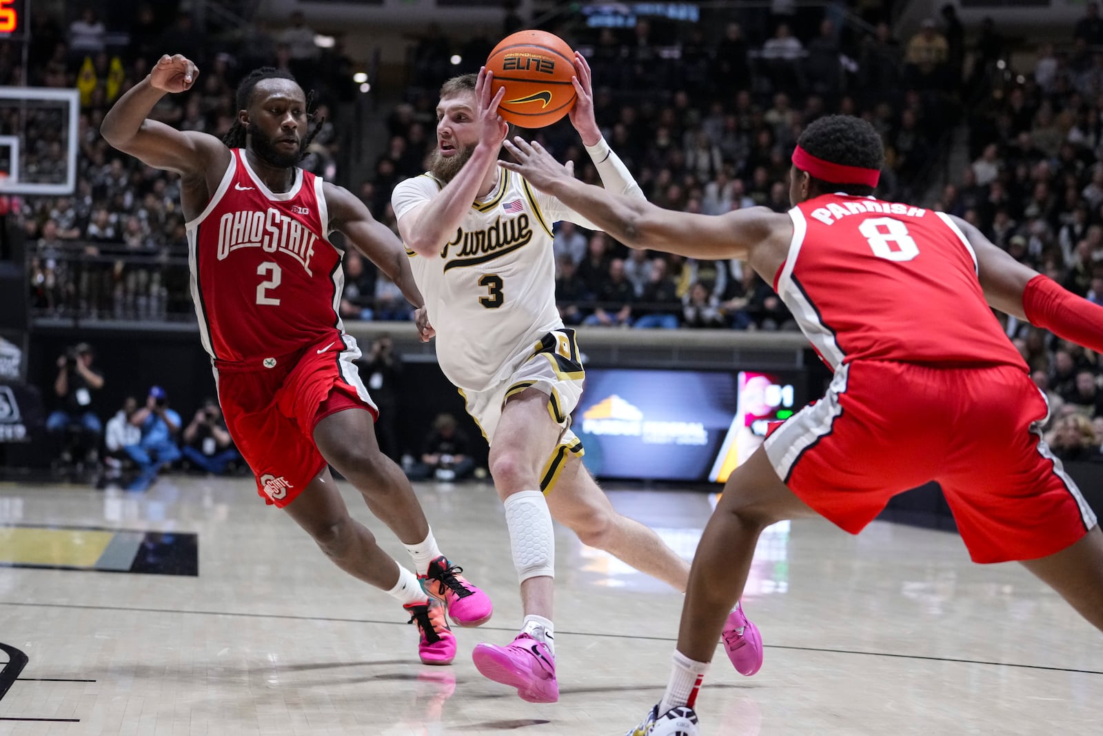 Purdue guard Braden Smith (3) drives between Ohio State guard Bruce Thornton (2) and guard Micah Parrish (8) during the second half of an NCAA college basketball game in West Lafayette, Ind., Tuesday, Jan. 21, 2025. (AP Photo/Michael Conroy)