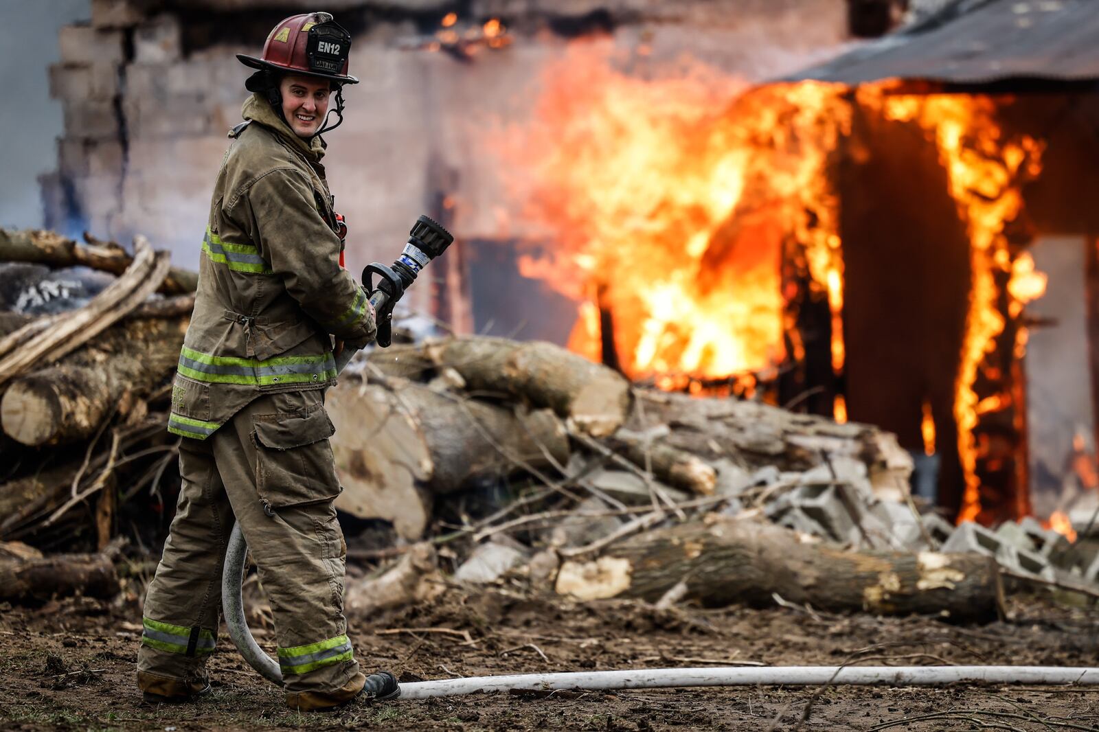 An outdoor fire apparently was spread by wind Thursday, March 31, 2022, to a wooden structure behind a house in the 3700 block of Old Troy Pike in Riverside. JIM NOELKER/STAFF