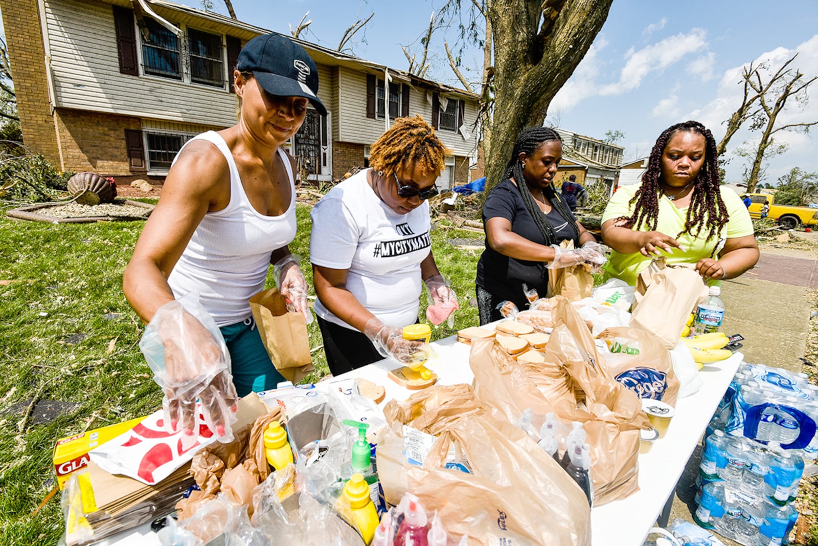 Left to right: Michelle Farris, Ashley Browning, Ashley Stephens and Ashley Corporal, with volunteer group SoLoved set up a table on Olive Tree Drive in Trotwood to helps serve food and water to those in need in the area Tuesday, May 28 after overnight tornadoes ripped through the  region. NICK GRAHAM/STAFF