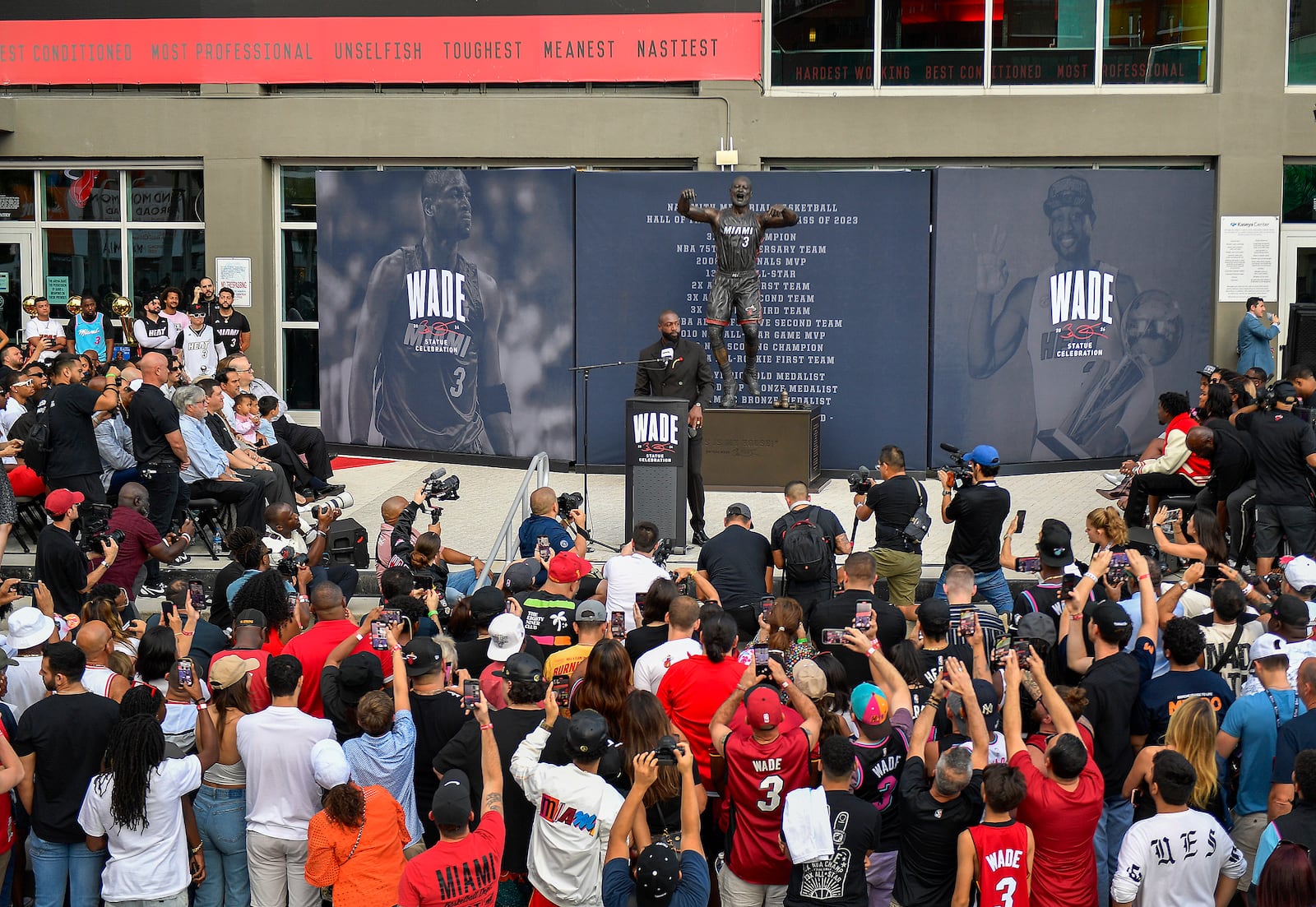 Former Miami Heat NBA basketball player Dwyane Wade, center, speaks during his statue unveiling ceremony outside the Kaseya Center, Sunday, Oct. 27, 2024, in Miami, Fla. (AP Photo/Michael Laughlin)