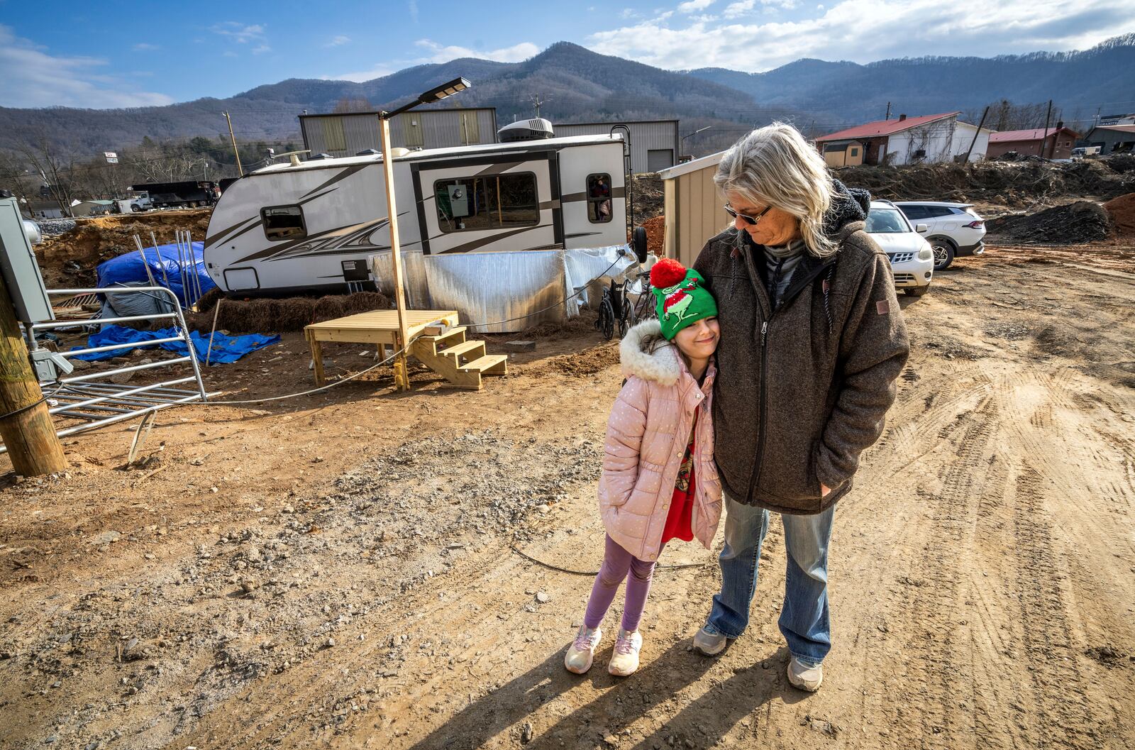 Vickie Revis and her granddaughter, Addisun Cole, 8, stand outside the trailer on Revis' property where she's currently living after her home was destroyed by Hurricane Helene, Wednesday, Feb. 5, 2025, in Swannanoa, N.C. (AP Photo/Kathy Kmonicek)