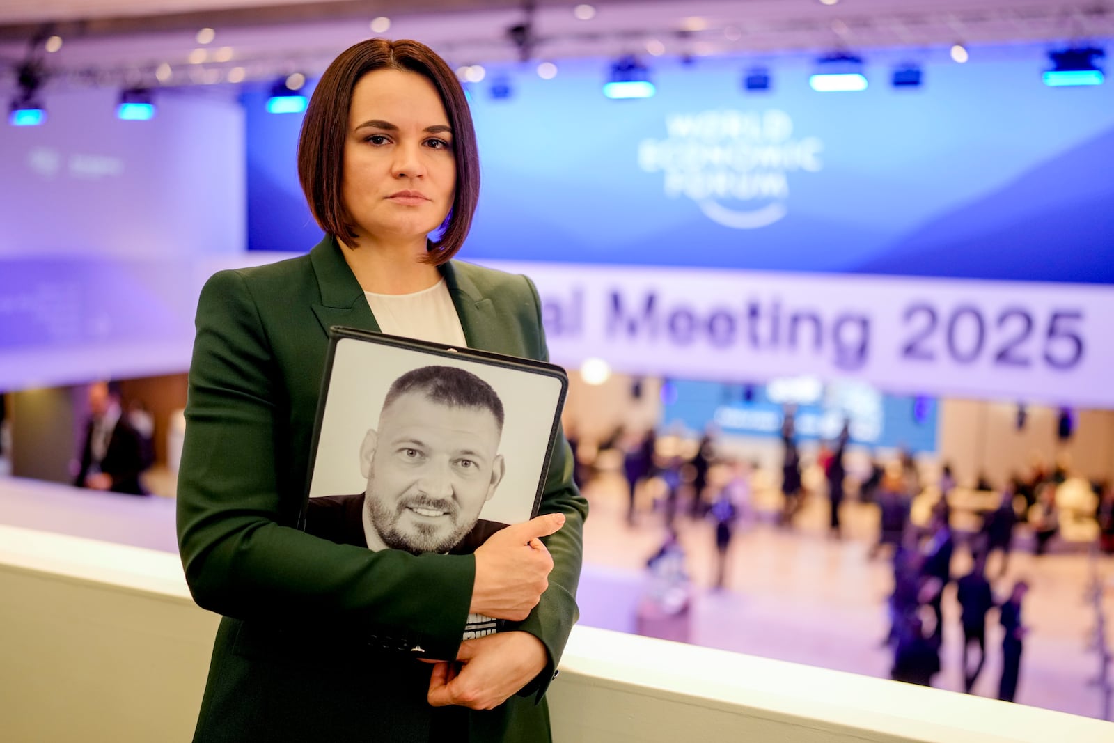 FILE – Belarusian opposition leader Sviatlana Tsikhanouskaya holds a photo of her imprisoned husband, Syarhei Tsikhanouski, at the annual World Economic Forum in Davos, Switzerland, on Jan. 21, 2025. (AP Photo/Markus Schreiber, File)