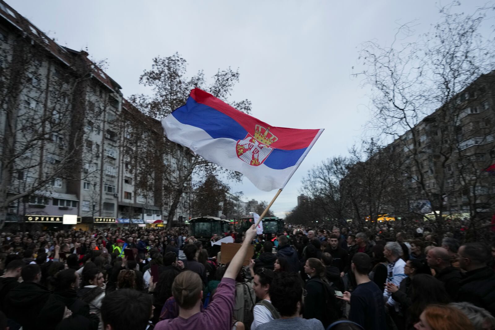 A man holds a Serbian flag during a protest, day after the assault on students was carried out by thugs with baseball bats, in Novi Sad, Serbia, Tuesday, Jan. 28, 2025. (AP Photo/Darko Vojinovic)