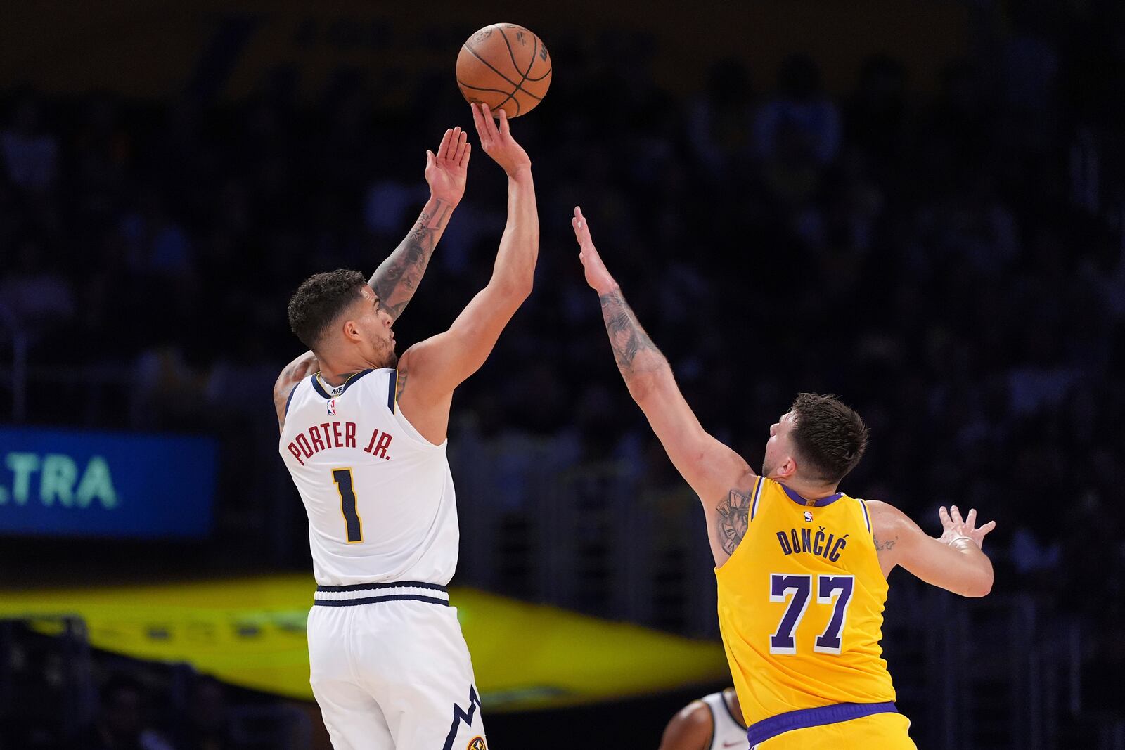 Denver Nuggets forward Michael Porter Jr., left, shoots as Los Angeles Lakers guard Luka Doncic defends during the first half of an NBA basketball game Wednesday, March 19, 2025, in Los Angeles. (AP Photo/Mark J. Terrill)