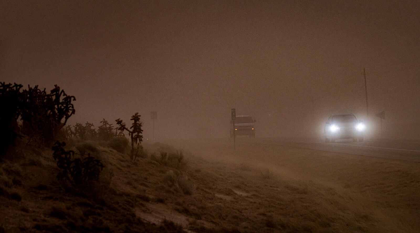 The wind and dust sweep over Highway 14 obscuring the road and the sky on Tuesday, March 18, 2025, in Santa Fe, N.M. (Gabriela Campos/Santa Fe New Mexican via AP)