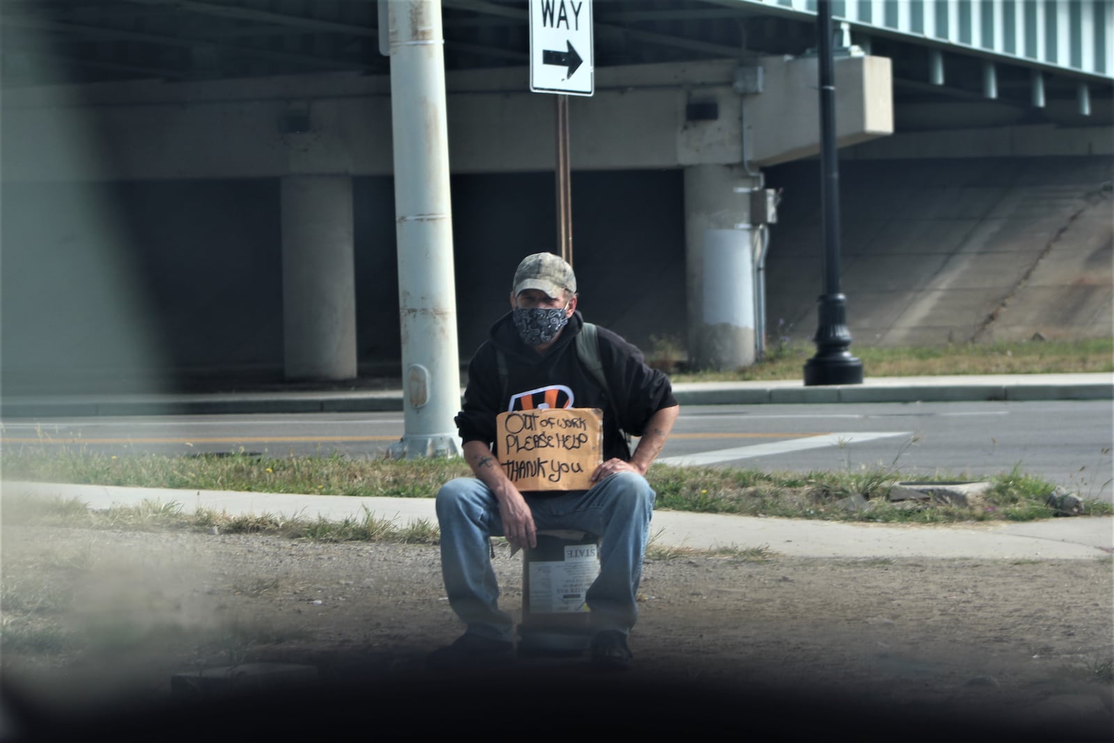 A citizen downtown by the U.S. 35 overpass holds a sign saying "Out of work. Please help. Thank you." CORNELIUS FROLIK / STAFF