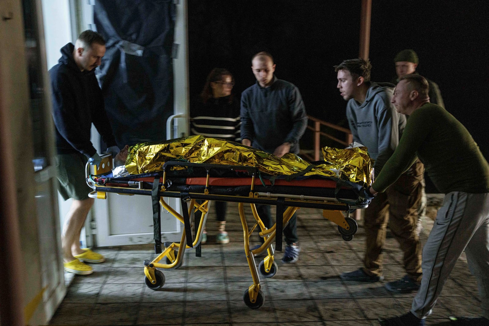 Medics haul an injured Ukrainian serviceman on a stretcher from an ambulance at Medical Service "Ulf" of the 108th Separate Battalion "Da Vinci Wolves" on Pokrovsk direction, Ukraine, Tuesday, Dec. 24, 2024. (AP Photo/Evgeniy Maloletka)