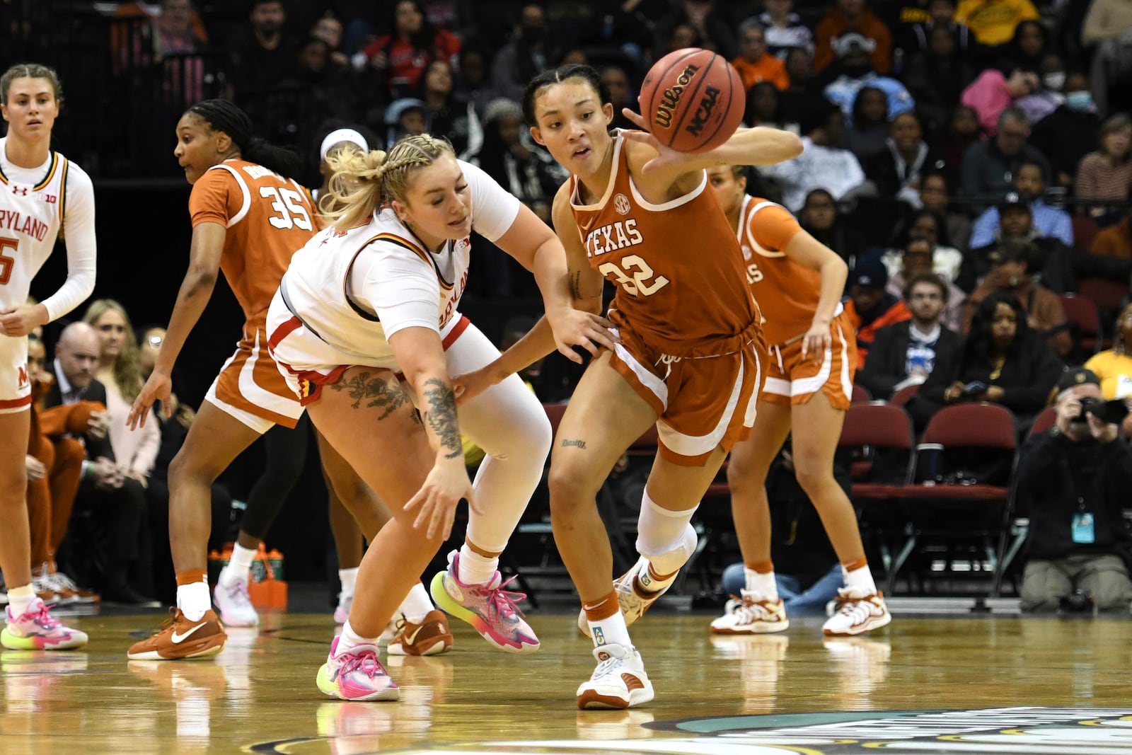 Maryland forward Allie Kubek, center left, and Texas guard Ndjakalenga Mwenentanda, center right, chase after the ball during the first half of an NCAA college basketball game Monday, Jan. 20, 2025, in Newark, N.J. (AP Photo/Pamela Smith)