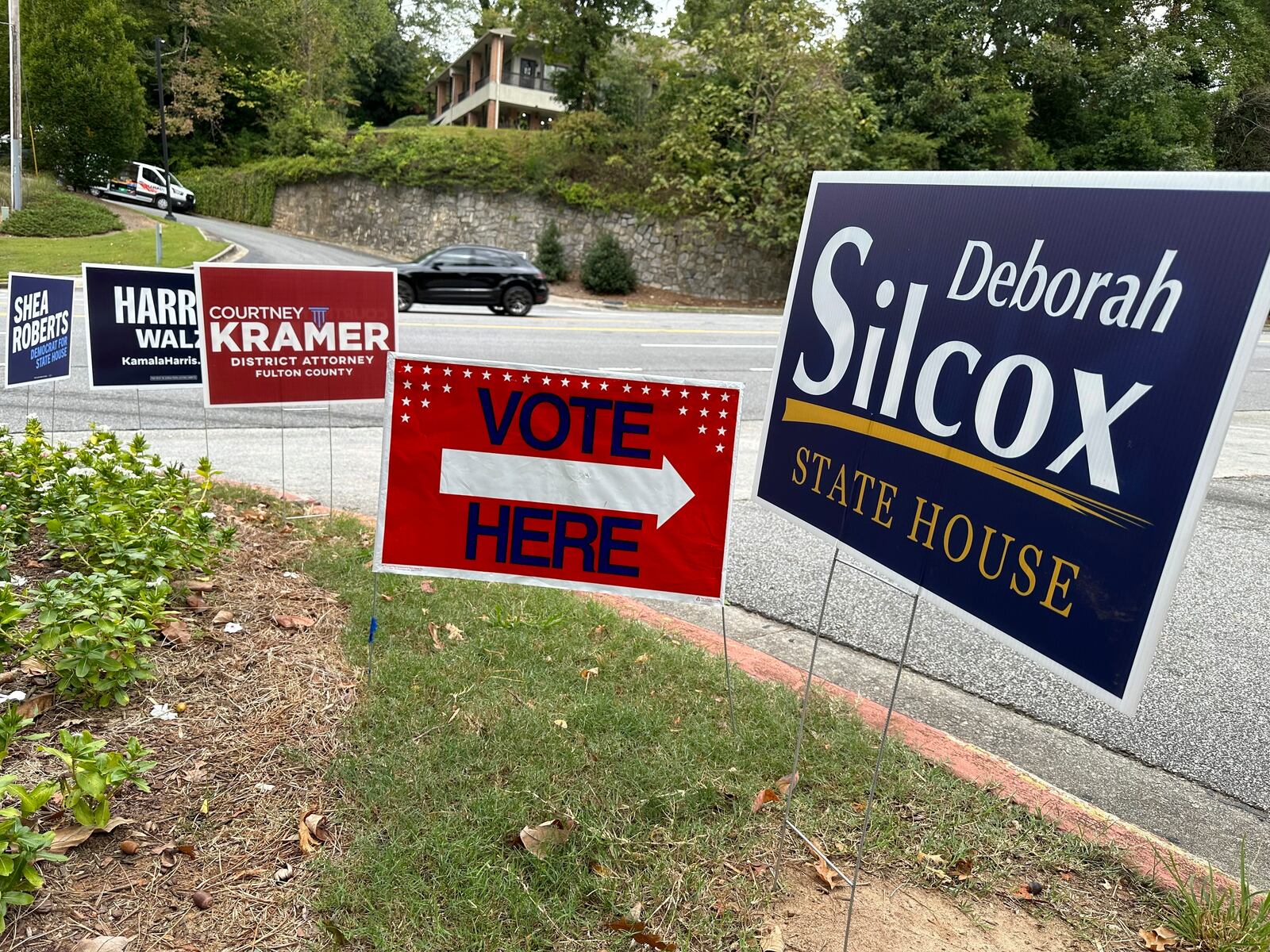 Signs entice voters in the Atlanta suburb of Sandy Springs, Ga., Tuesday, Oct. 15, 2024, the first day of early in-person voting in Georgia. (AP Photo/Jeff Amy)