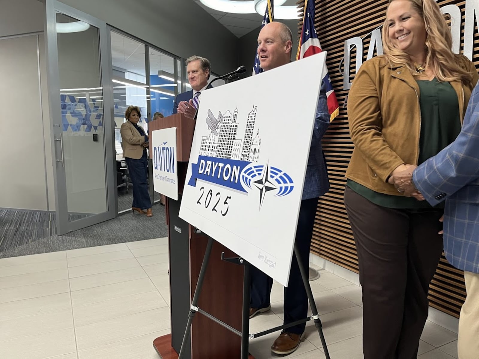 Springboro graphic artist Kim Swigart behind the logo she designed for next May's NATO Parliamentary Assembly spring session, to be held in Dayton. THOMAS GNAU/STAFF