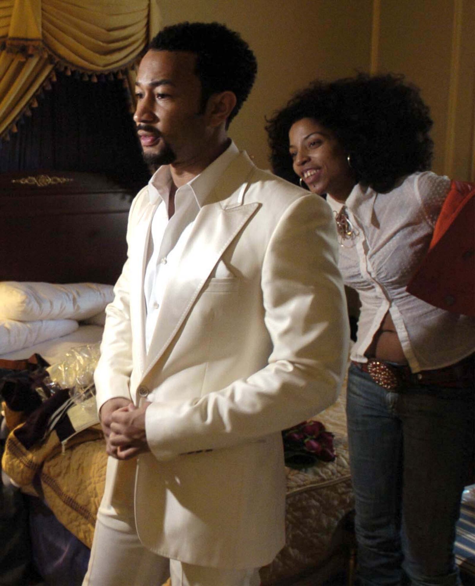 Stylist Lisa Sellers helps John Legend get ready in his Los Angeles hotel room for the Grammy Awards in 2006. The tux was one of several outfits she picked out for him to change into during the night. MARSHALL GORBY / STAFF