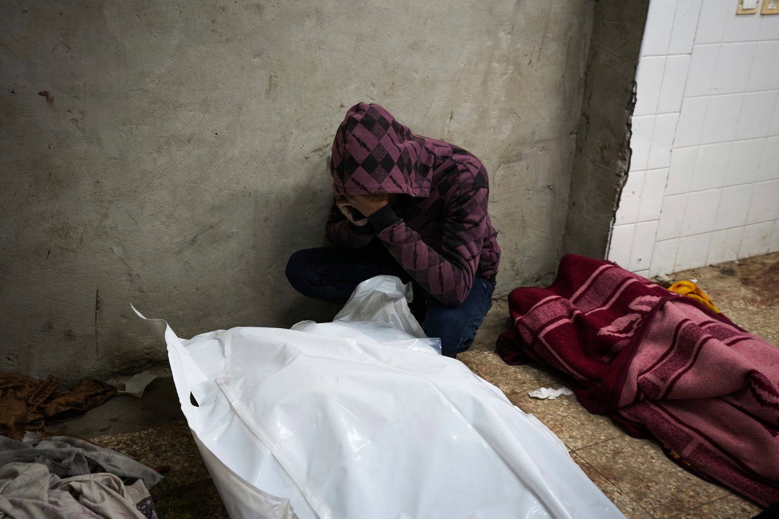 A man mourn over the bodies of two members of Abeid family who were killed in the Israeli bombardment in Maghazi, central Gaza Strip, at Al-Aqsa Martyrs Hospital in Deir al-Balah, Tuesday, Jan. 7, 2025. (AP Photo/Abdel Kareem Hana)