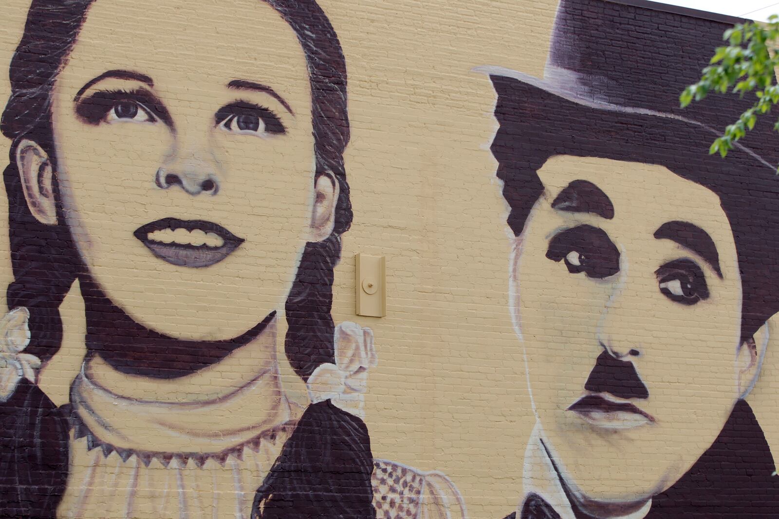 A new mural in downtown Miamisburg pays  tribute to Hollywood legends. Towering portraits - 35- feet tall - of John Wayne, Carrie Fisher, Paul Newman, Judy Garland and Charlie Chaplain have been created on the north wall of the Plaza Theatre, 33 S. Main St. Artist Erica Arndts, a Centerville native, said she wanted to âpay honor to vintage Hollywood characters,â as she put the finishing touches on the 100-foot-long mural. LISA POWELL / STAFF