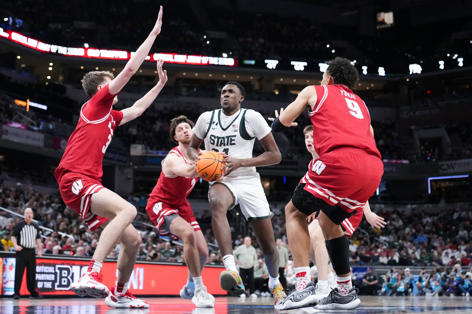 Michigan State forward Xavier Booker (34) drives on Wisconsin forward Nolan Winter, left, and John Tonje (9) during the first half of an NCAA college basketball game in the semifinals of the Big Ten Conference tournament in Indianapolis, Saturday, March 15, 2025. (AP Photo/Michael Conroy)