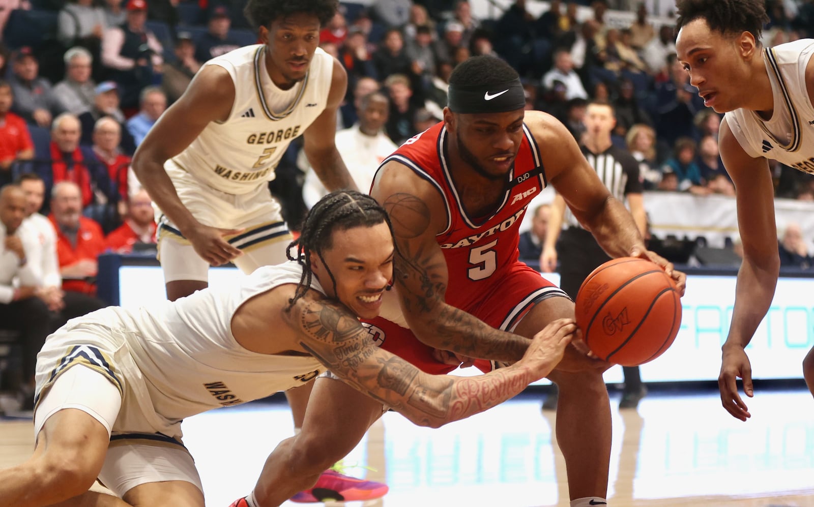 Dayton's Posh Alexander battles for possession against George Washington on Saturday, Jan. 4, 2025, at the Charles E. Smith Center in Washington, D.C. David Jablonski/Staff