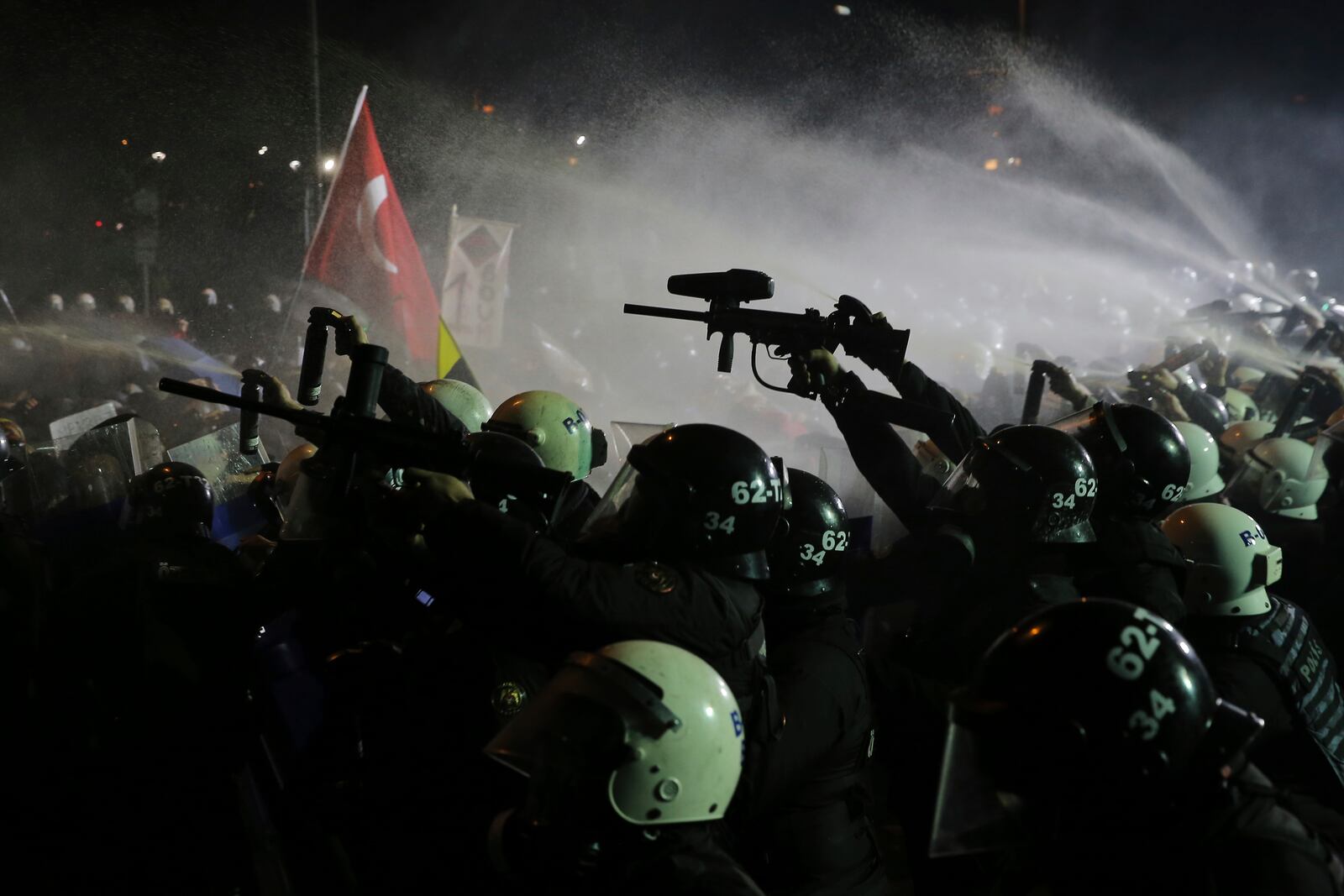 Riot police officers use anti riot rifles and pepper spray to clear protesters during a protest after Istanbul's Mayor Ekrem Imamoglu was arrested and sent to prison, in Istanbul, Turkey, Sunday, March 23, 2025. (AP Photo/Huseyin Aldemir)