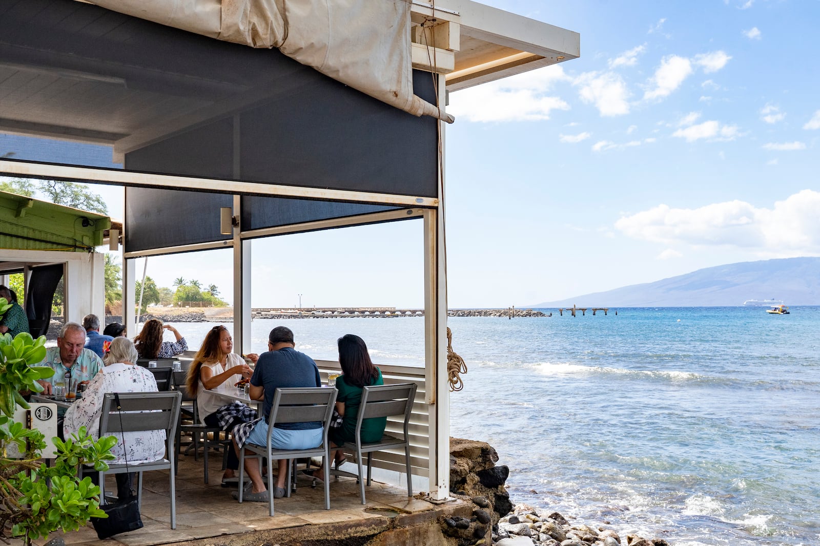 Guests enjoy their lunch at Mala Ocean Tavern, Monday, Nov. 18, 2024, in Lahaina, Hawaii. Mala Ocean Tavern is the first restaurant on Front Street to reopen after last year's wildfire. (AP Photo/Mengshin Lin)