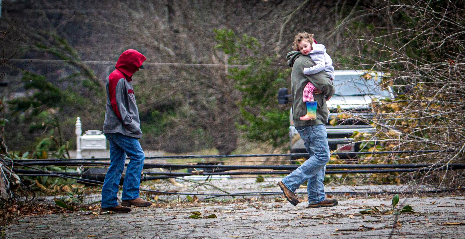 A man carries a little girl to a truck from a house amidst debris from a storm in east Tuscumbia, Ala., Sunday, Feb. 16, 2025. (Dan Busey/The TimesDaily via AP)