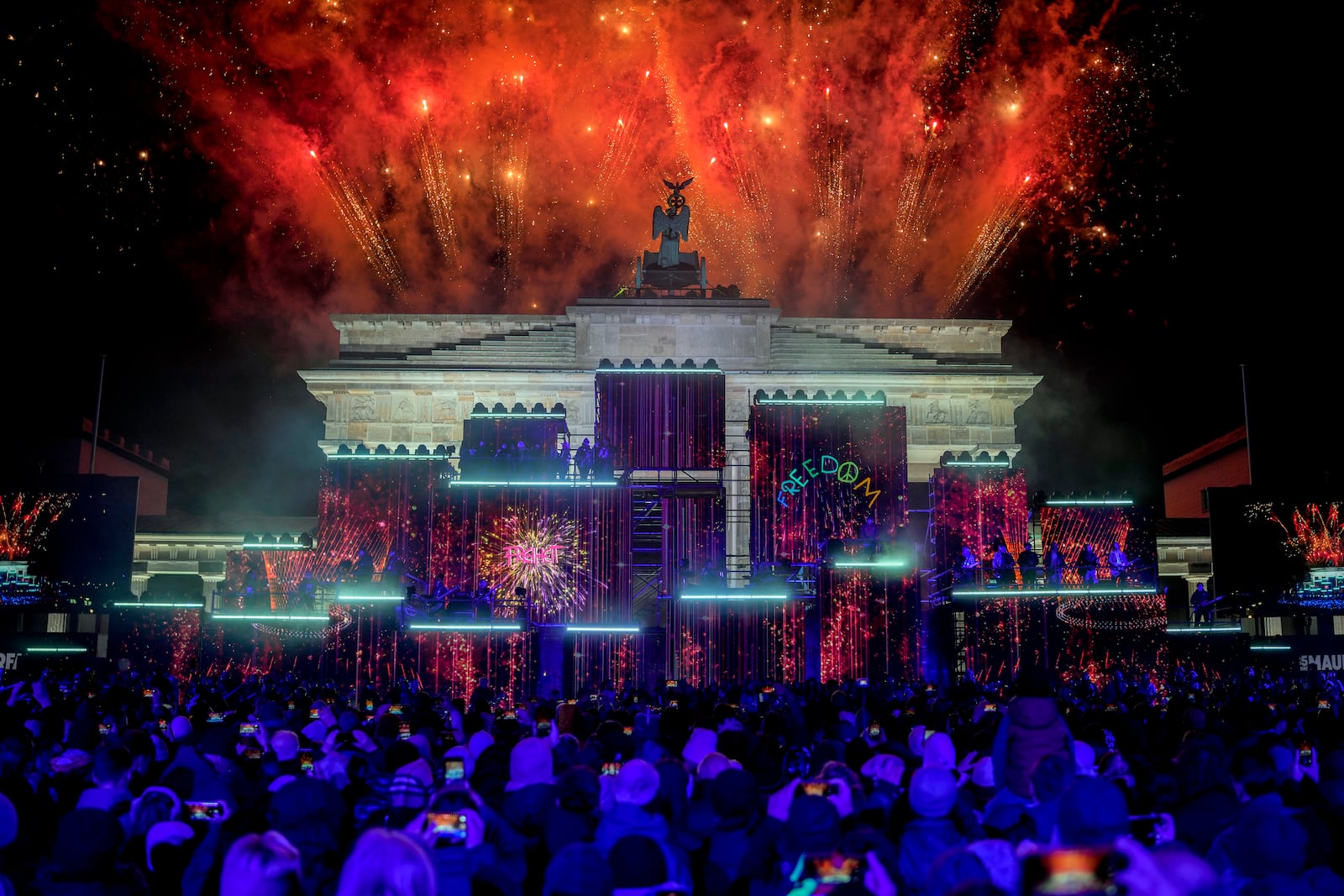 Fireworks light the sky during the as musicians play on stage during the concert for freedom for the 35th anniversary of the fall of the Berlin Wall, in Berlin, Germany, Saturday, Nov. 9, 2024. (AP Photo/Ebrahim Noroozi)