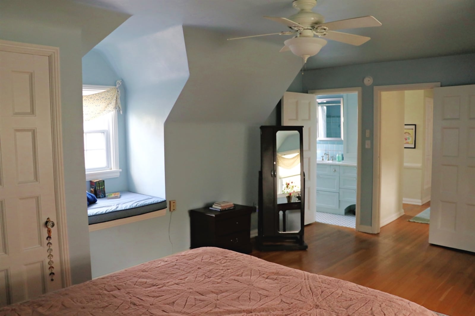 The primary bedroom is at the end of the hallway and has a large window seat.