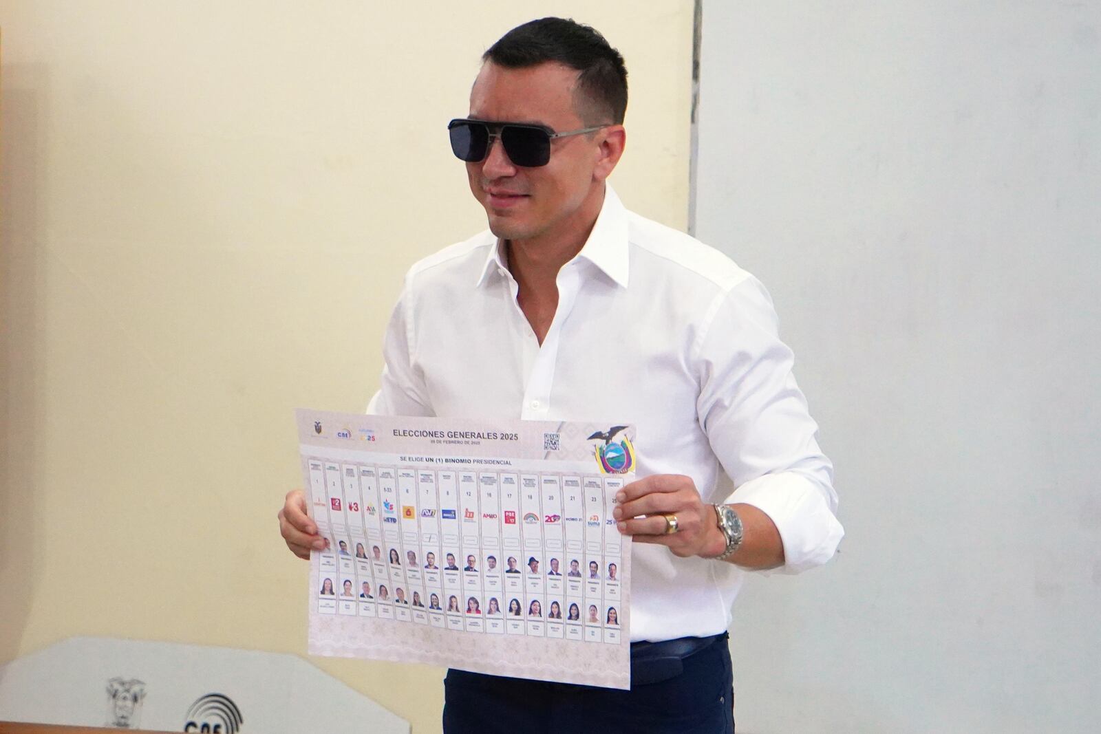 President Daniel Noboa, who is running for reelection, holds up his ballot before voting in the presidential election in Olon, Ecuador, Sunday, Feb. 9, 2025. (AP Photo/Cesar Munoz)