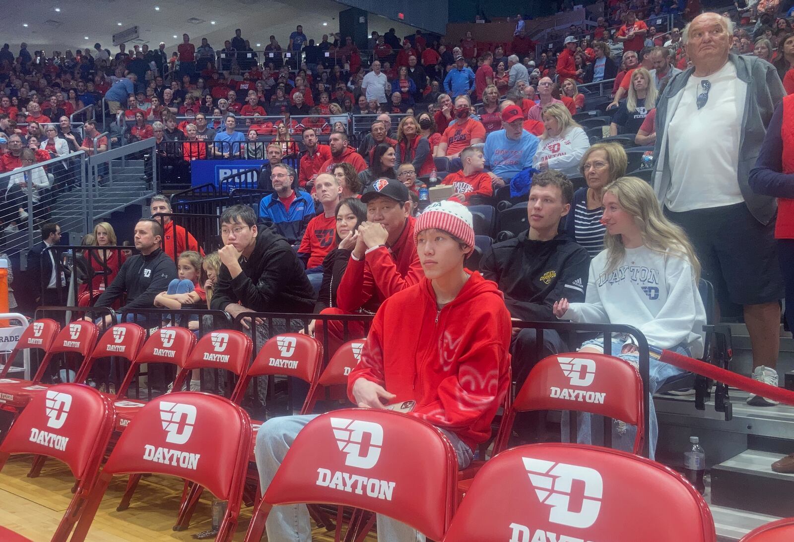 Dayton recruit Mike Sharavjamts sits behind the bench during a game against Davidson on Saturday, March 5, 2022, at UD Arena. David Jablonski/Staff