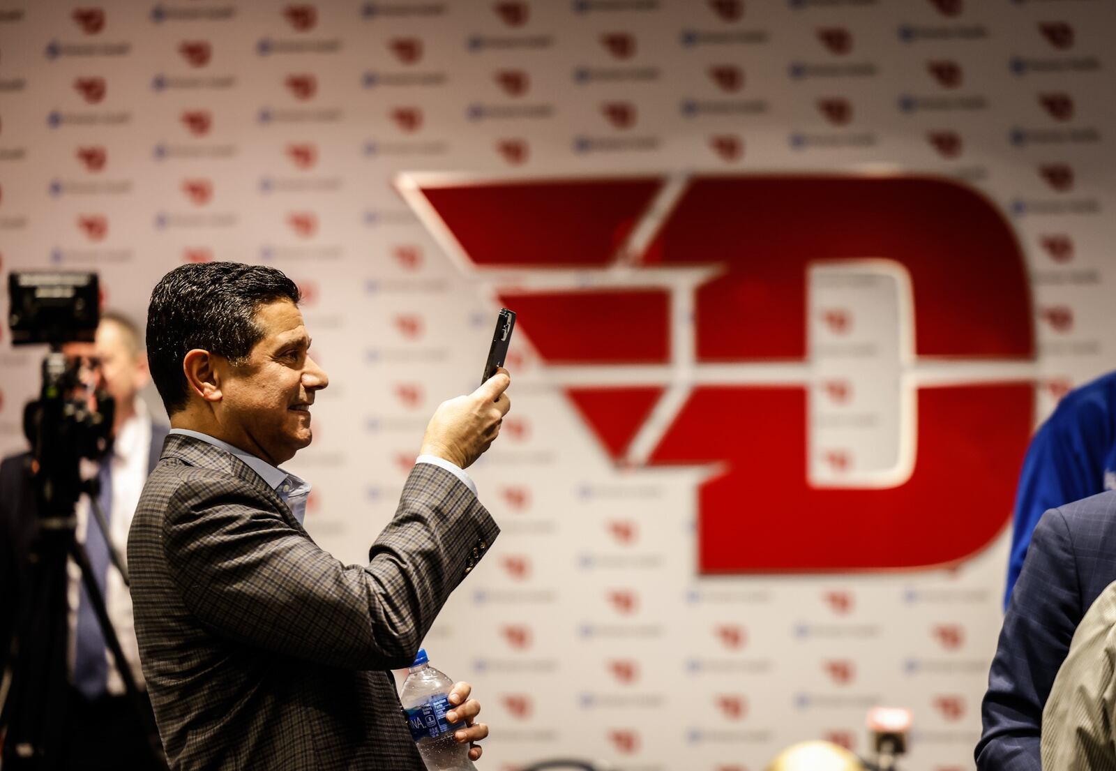 J.P. Nauseef, co-founder of the Big Hoopla and a member of its Local Organizing Committee, takes photographs at a press conference promoting UD Arena hosting the First Flour and the state high school championships. JIM NOELKER/STAFF