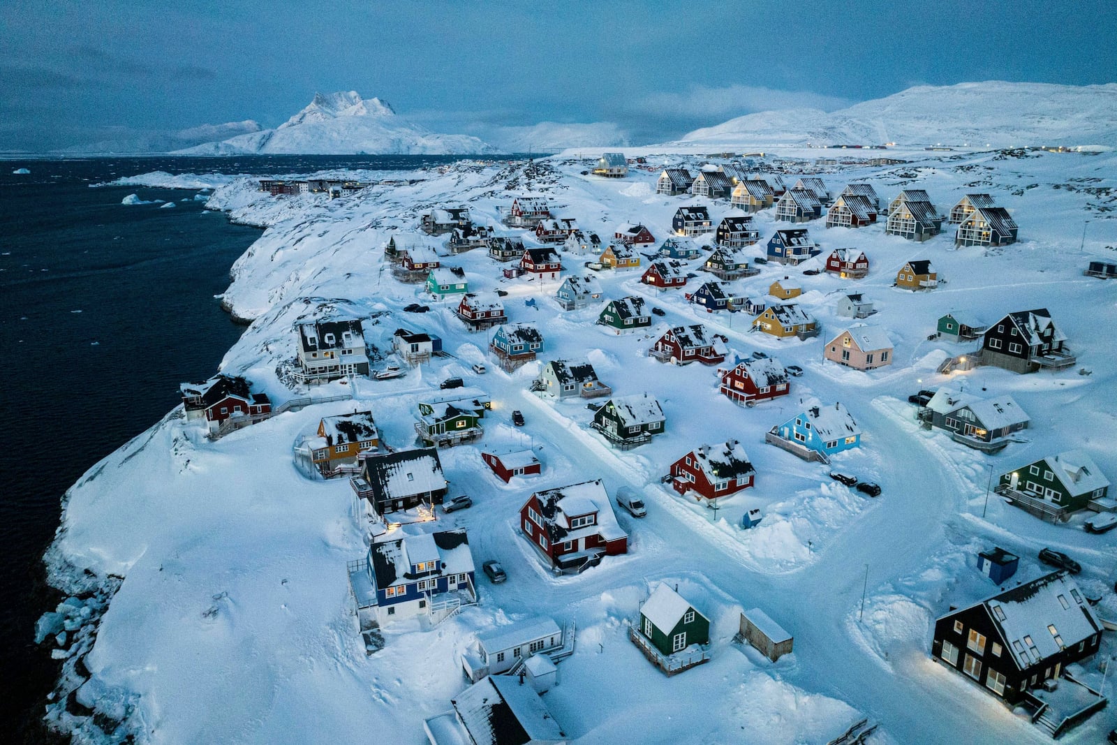 FILE - Houses covered by snow are seen on the coast of a sea inlet of Nuuk, Greenland, Friday, March 7, 2025. (AP Photo/Evgeniy Maloletka, File)