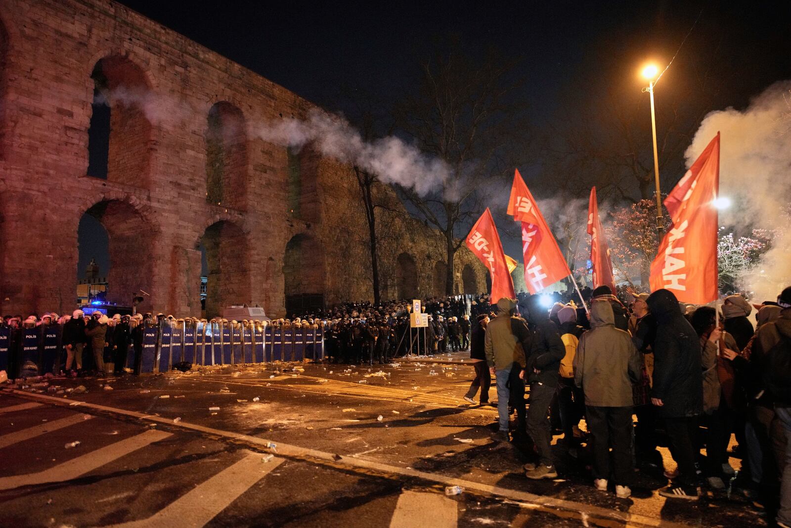 Protesters throw a flare towards anti riot police officers during a protest against the arrest of Istanbul's Mayor Ekrem Imamoglu in Istanbul, Turkey, Friday, March 21, 2025. (AP Photo/Emrah Gurel)