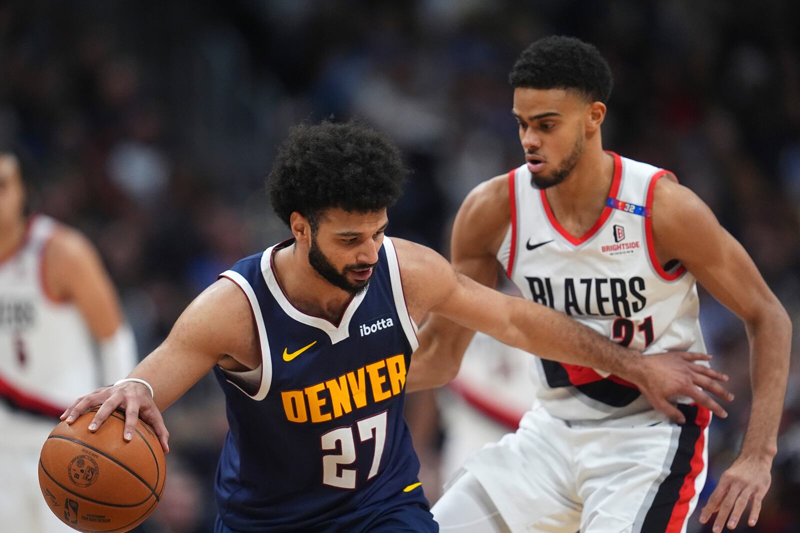 Denver Nuggets guard Jamal Murray, left, collects a loose ball as Portland Trail Blazers guard Rayan Rupert defends in the second half of an NBA basketball game Wednesday, Feb. 12, 2025, in Denver. (AP Photo/David Zalubowski)