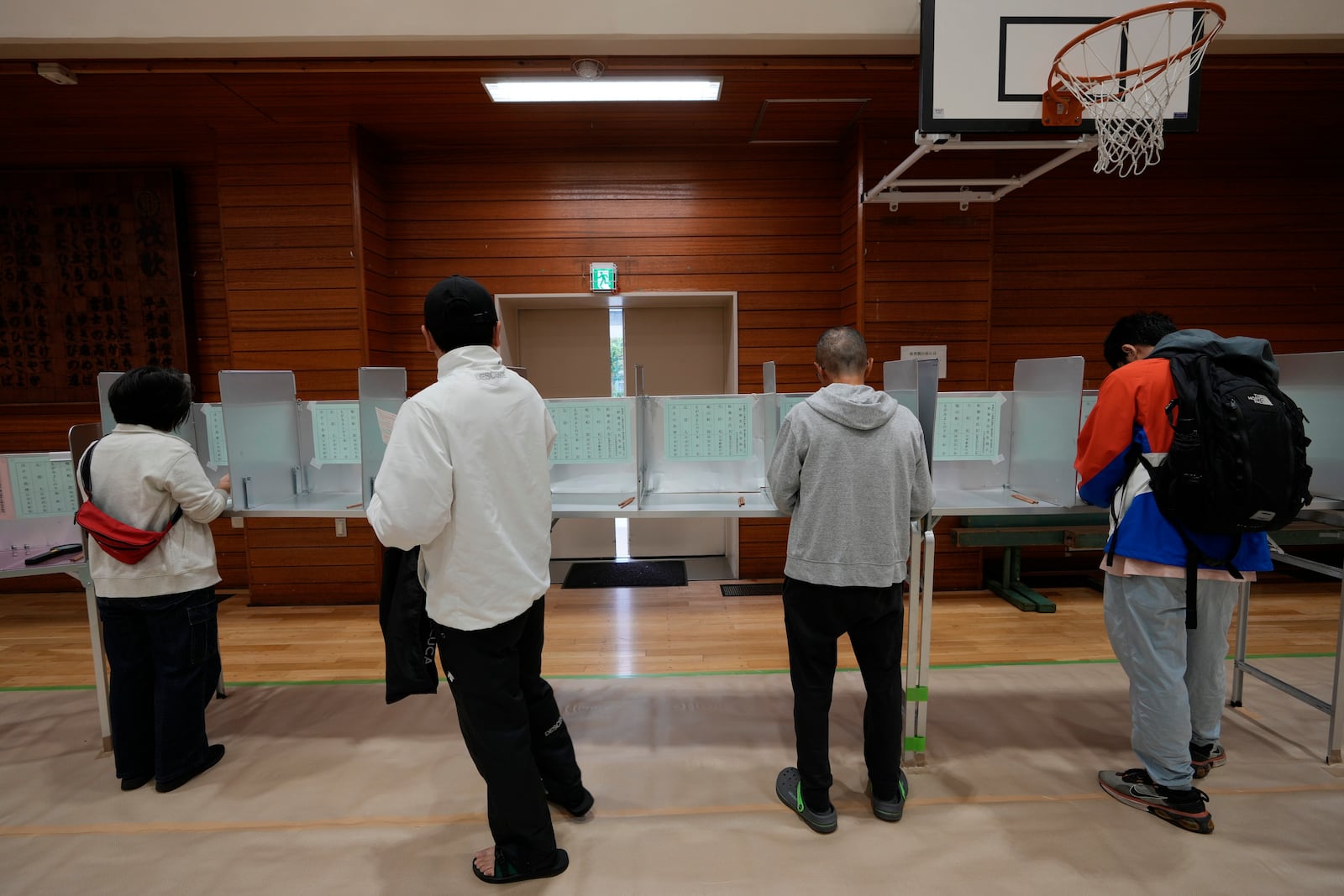 Voters prepare to cast their ballots at a polling station for Japan's lower house election in Tokyo, Japan, Sunday, Oct. 27, 2024. (AP Photo/Hiro Komae)