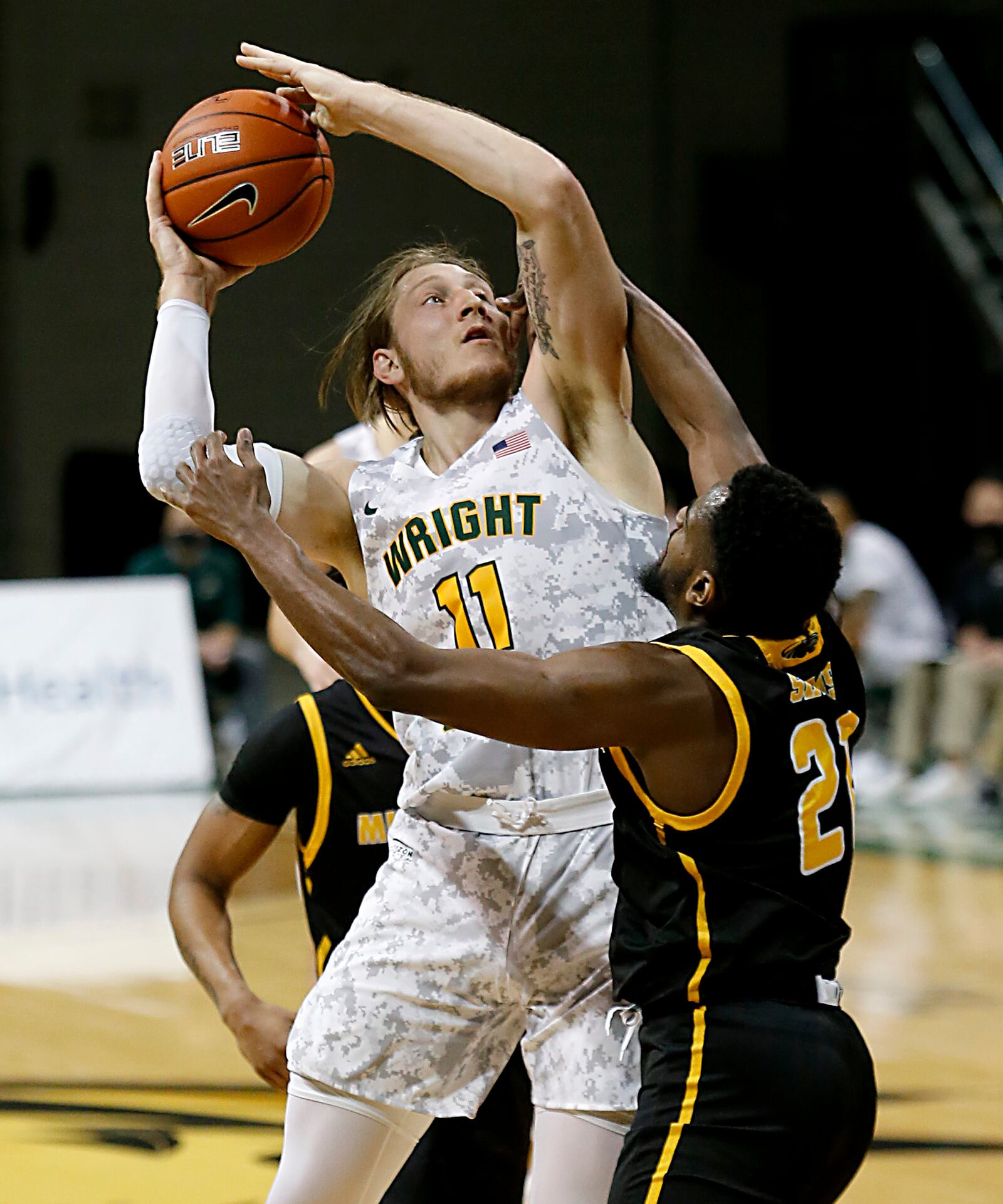 Wright State center Loudon Love scores despite the pressure of Milwaukee forward Tafari Simms during a Horizon League quarterfinal at the Nutter Center in Fairborn Mar. 2, 2021. Wright State lost 94-92. E.L. Hubbard/CONTRIBUTED