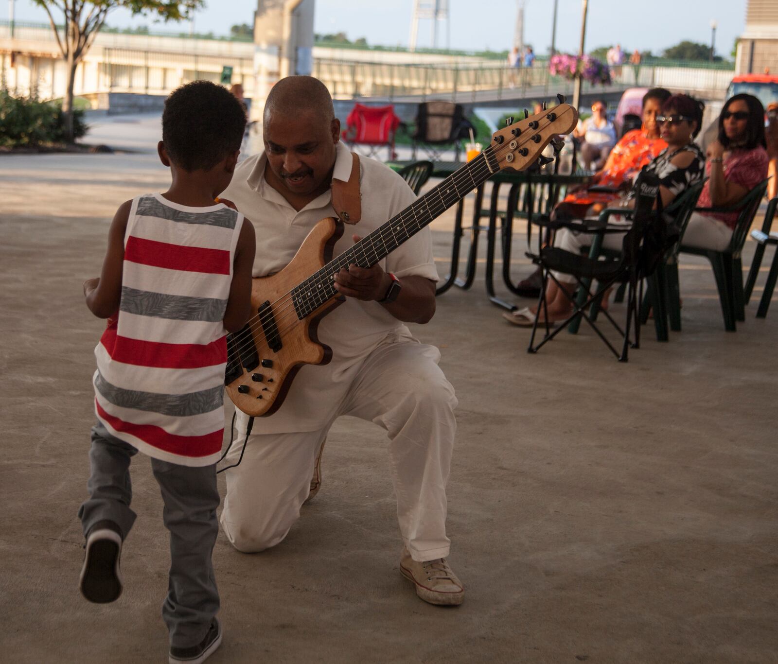 A musician interacting with a child during a concert at RiverScape MetroPark.