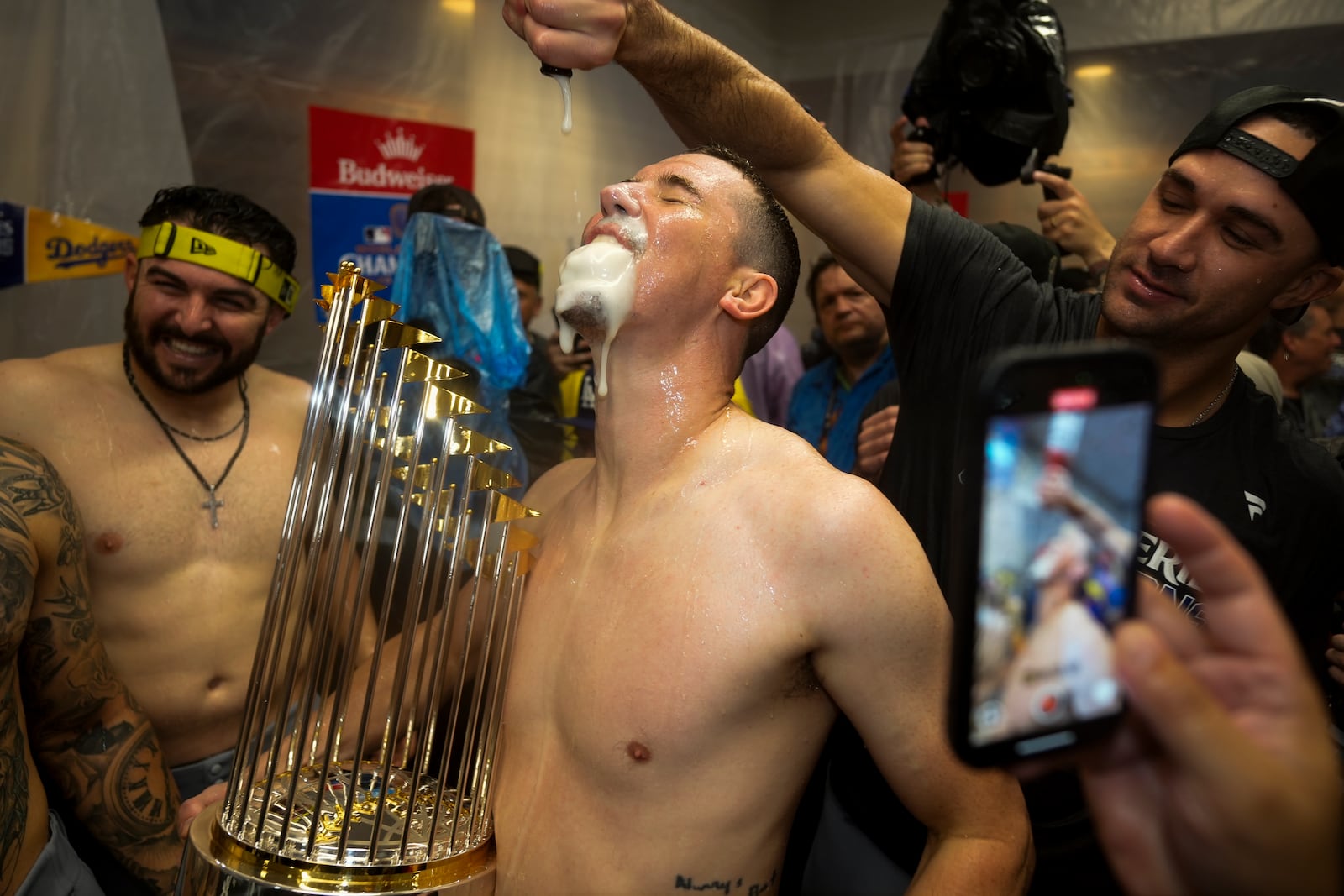 Los Angeles Dodgers pitcher Walker Buehler celebrates in the locker room after their win against the New York Yankees in Game 5 to win the baseball World Series, Thursday, Oct. 31, 2024, in New York. (AP Photo/Ashley Landis)