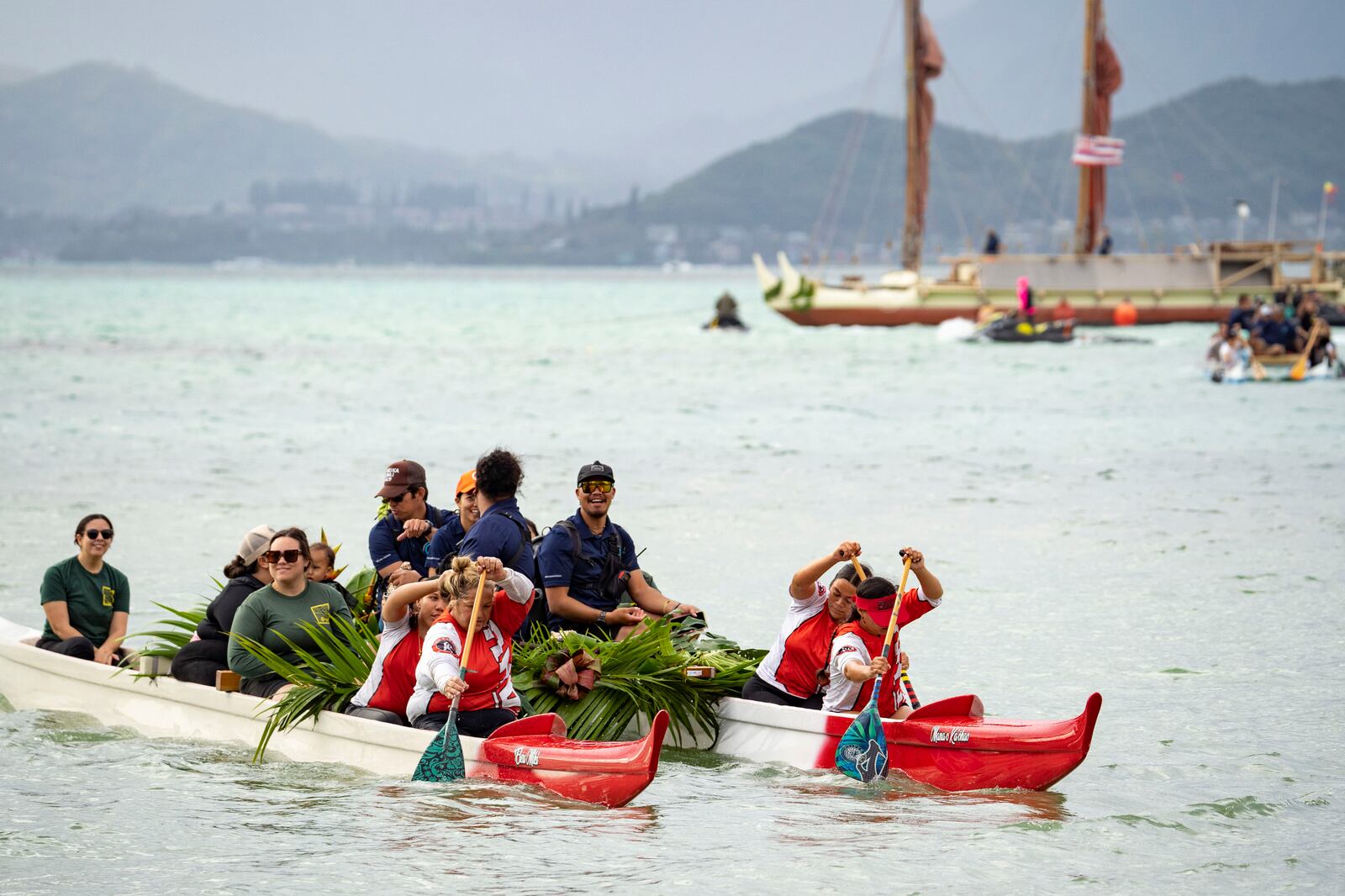 Kaneohe Canoe Club paddles the crew members of Hokulea before Hokulea's 50th birthday commemoration at Kualoa Regional Park, Saturday, March 8, 2025, in Kaneohe, Hawaii. (AP Photo/Mengshin Lin)