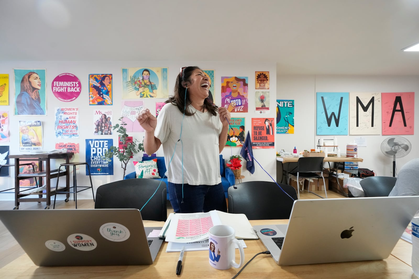 Emiliana Guereca, founder and president of the Women's March Foundation, laughs as she calls voters from a phone bank in Los Angeles on Tuesday, Oct. 15, 2024, and encourages them to vote for Democratic presidential nominee Vice President Kamala Harris. (AP Photo/Damian Dovarganes)