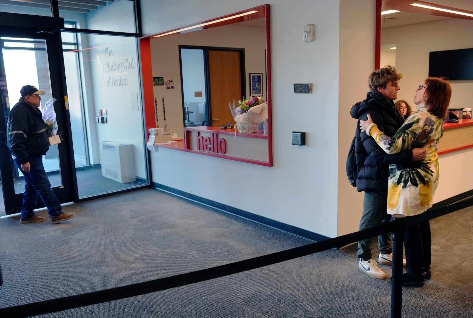 Two members of The Skating Club of Boston community embrace as flowers with condolences are delivered at the club, Thursday, Jan. 30, 2025, in Norwood, Mass. (AP Photo/Charles Krupa)