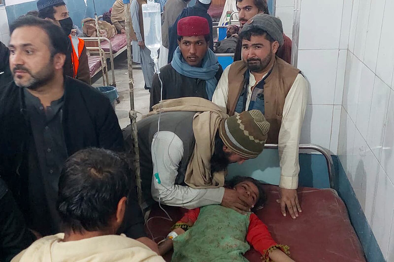 Family members stand around a girl injured in the bomb explosion as she receives treatment at a hospital in Bannu, northwest Pakistan, Tuesday, March 4, 2025. (AP Photo/Ehsan Ullah Khan)