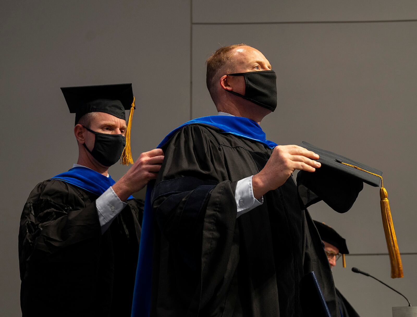 Lt. Col. James Rutledge (left), associate professor of aerospace engineering and senior military faculty, adjusts the hood of Lt. Col. Matthew Fuqua as he receives a doctorate of philosophy in aeronautical engineering from the Air Force Institute of Technology during a ceremony Sept. 16 at Wright-Patterson Air Force Base. U.S. AIR FORCE PHOTO/R.J. ORIEZ