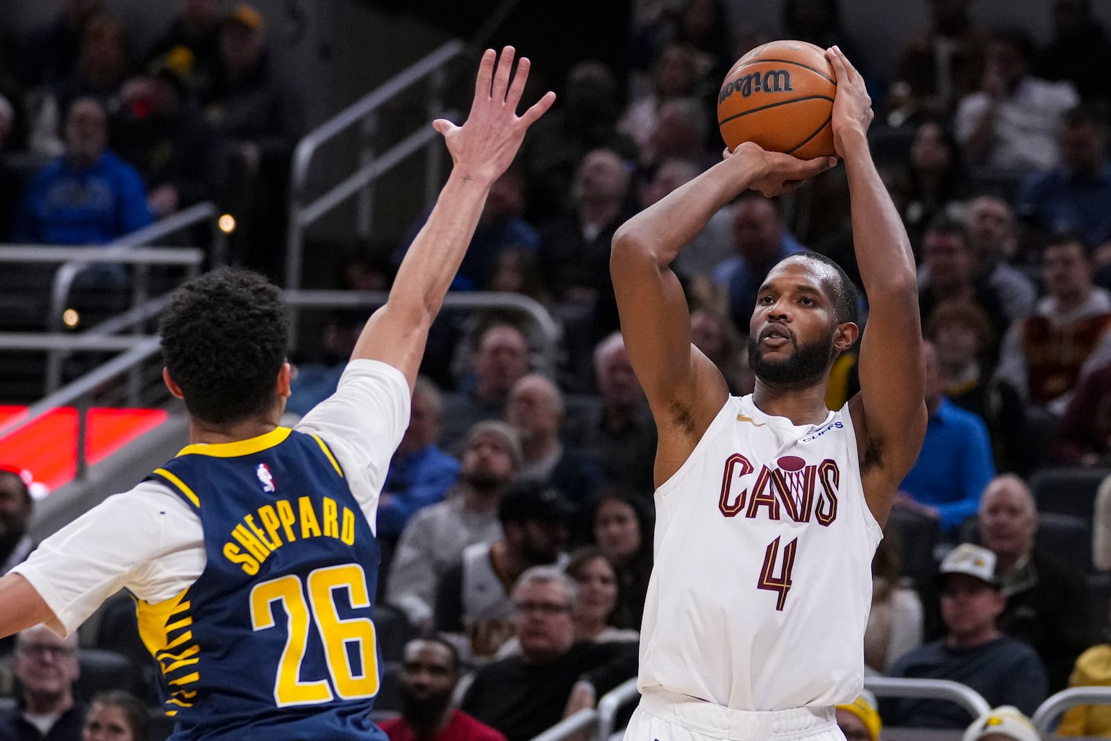 Cleveland Cavaliers forward Evan Mobley (4) shoots over Indiana Pacers guard Ben Sheppard (26) during the second half of an NBA basketball game in Indianapolis, Tuesday, Jan. 14, 2025. (AP Photo/Michael Conroy)