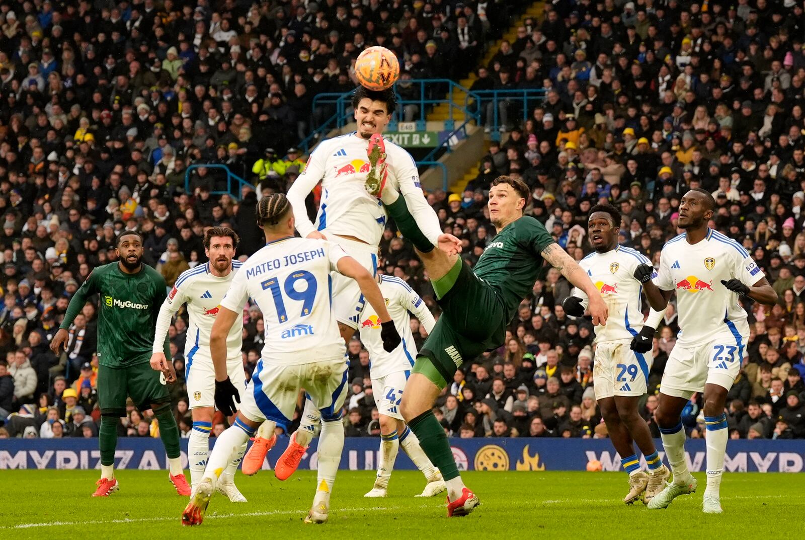 Leeds United's Pascal Struijk, top center, and Millwall's Jake Cooper, center right, battle for the ball during the English FA Cup fourth round soccer match at Elland Road, Leeds, England, Saturday, Feb. 8, 2025. (Danny Lawson/PA via AP)