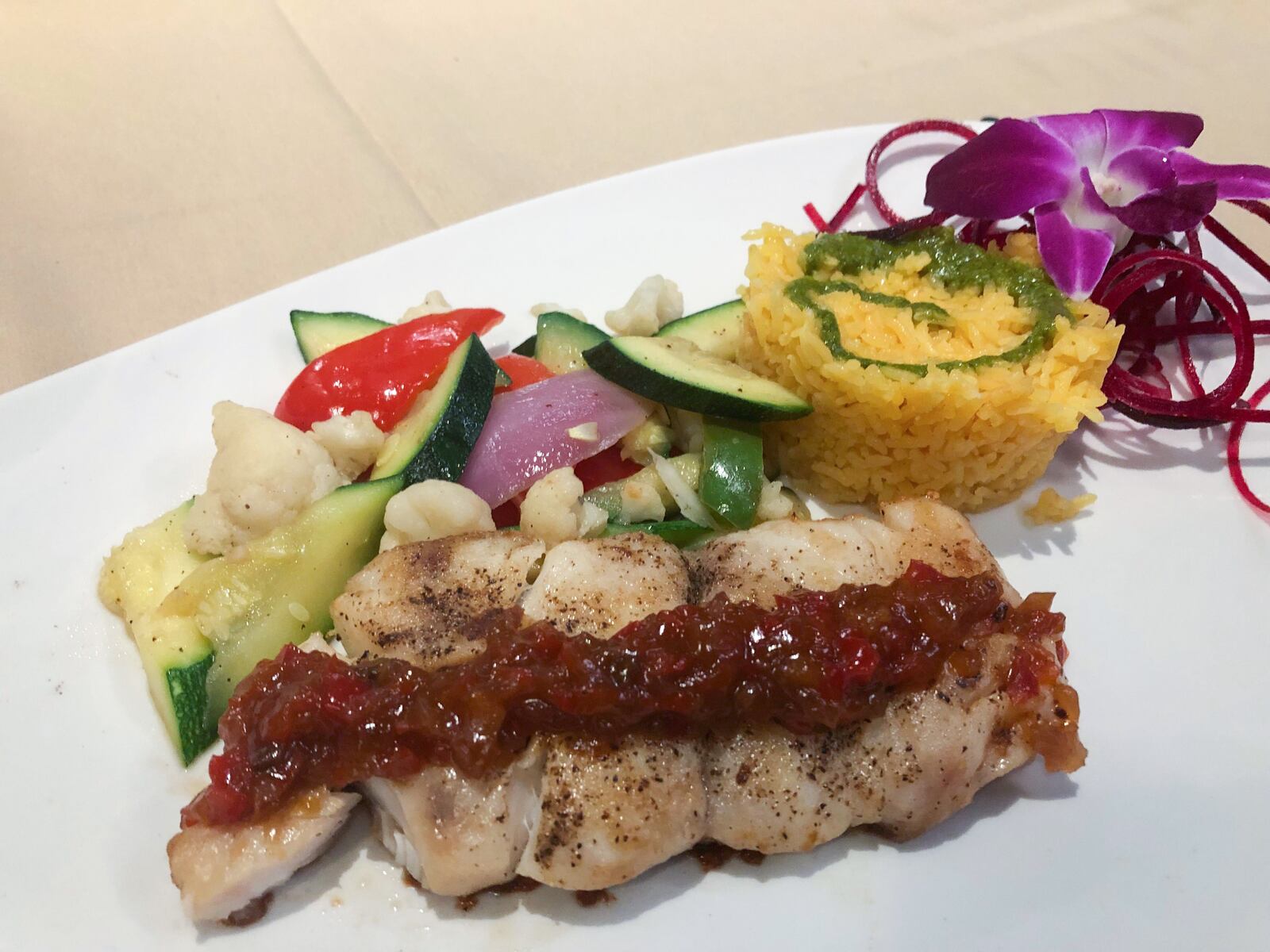 Florida Grouper  ( $34) served with tomato black bean sauce alongside cilantro rice and seasonal vegetables from Club Oceano. MARK FISHER / STAFF PHOTO