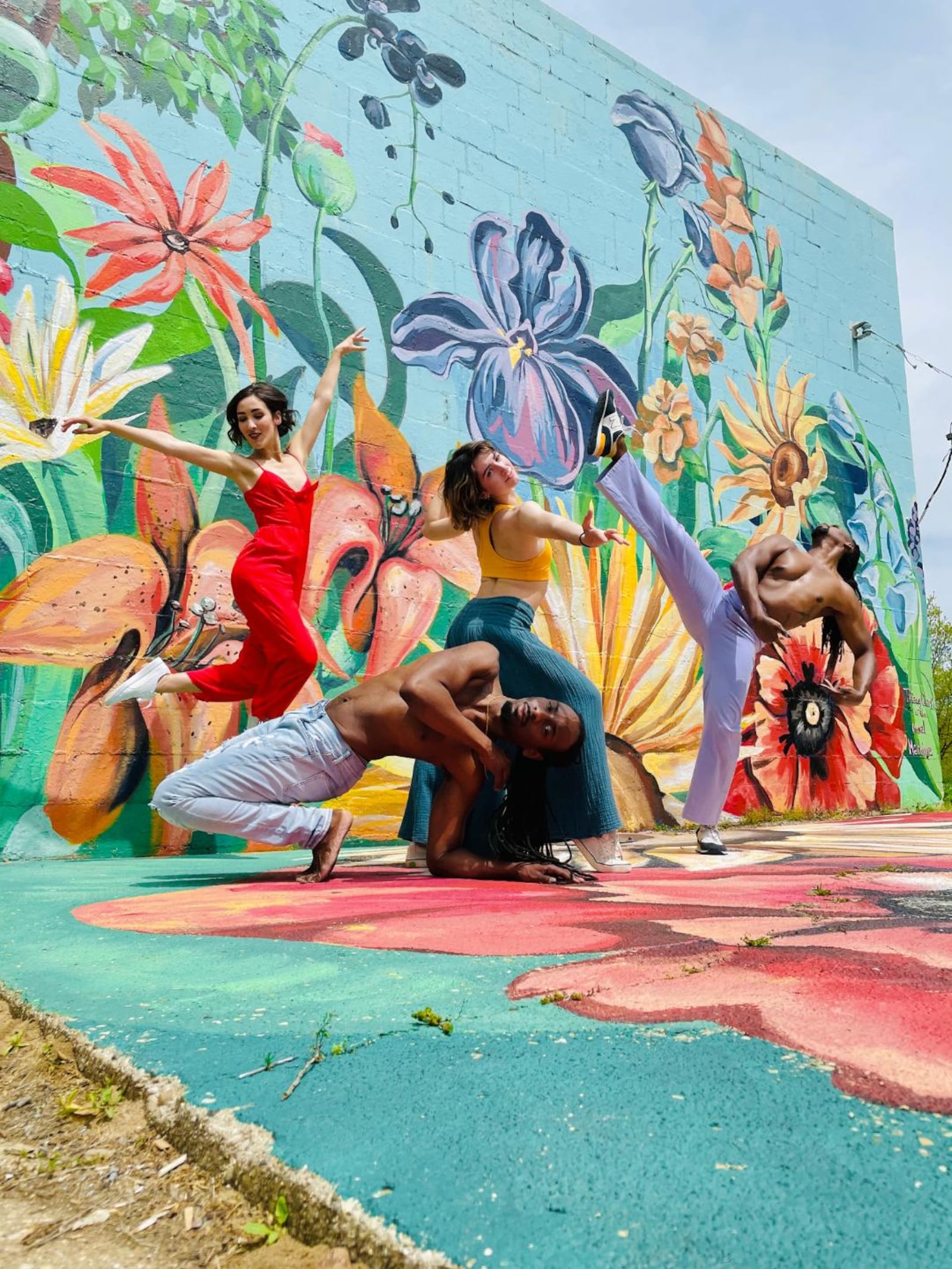 (left to right) Dayton Dance Initiative company members Miranda Dafoe, Devin Baker, Emilia Dagradi, and Quentin Sledge. (Mural by Tiffany Clark).