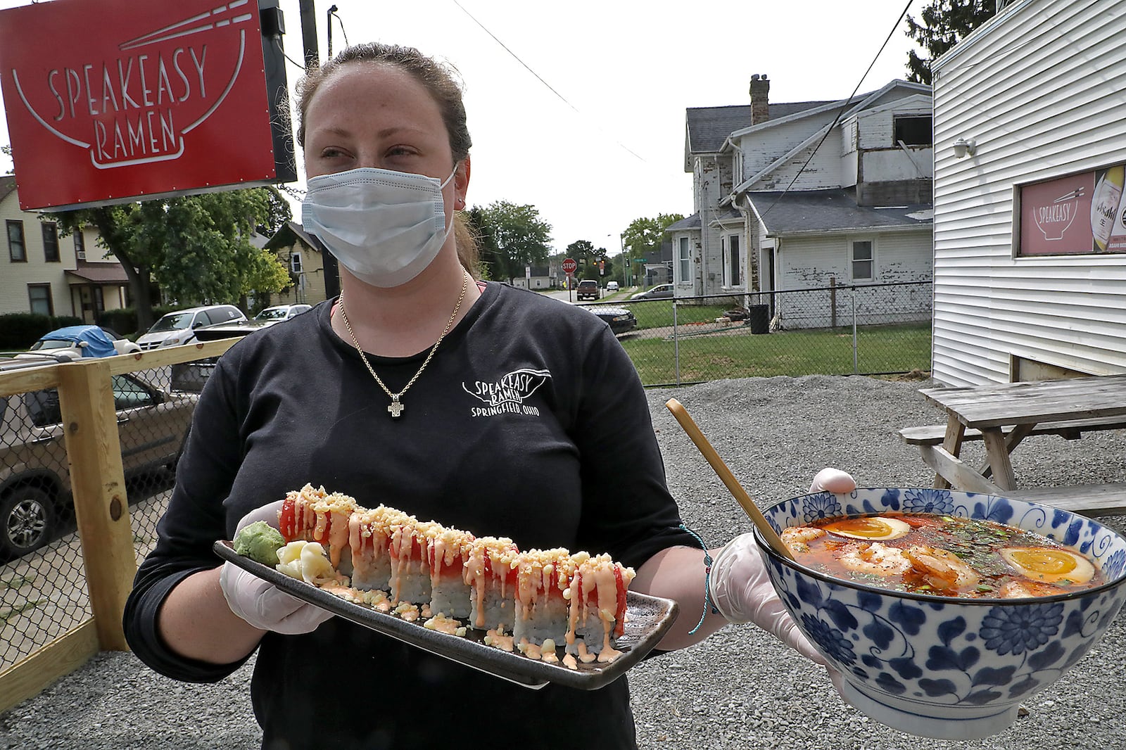 Brittany Waters delivers a customer's food on the new outdoor dinning area at Speakeasy Ramen in September 2020. Speakeasy Ramen earned a shout-out from the "Eat This, Not That" website as serving the "Best Ramen in Ohio," based on Yelp reviews. BILL LACKEY/STAFF