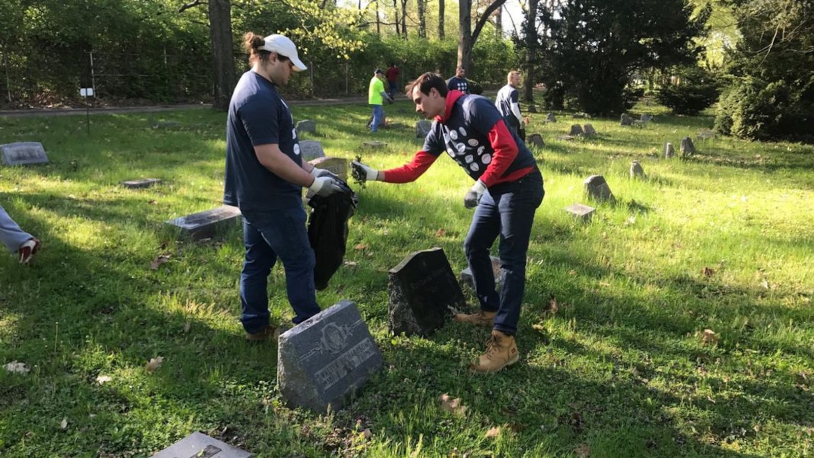 As part of the Rebuilding Together Dayton effort, Dayton Flyers offensive lineman Ryan Culhane and teammate Wil Bobek clean up around the grave of Hall of Fame Negro League pitcher Ray Brown at the overgrown and neglected Greencaste Cemetery on Nicholas Road in the West Dayton. Every year the UD football team takes part in the one-day citywide cleanup sponsored by Rebuilding Together Dayton, the nonprofit organization that rehabs homes for low income Dayton homeowners – especially the elderly – and preserves their neighborhoods. Tom Archdeacon/CONTRIBUTED