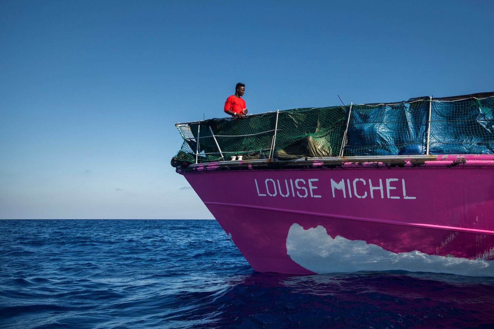 A man stands on the deck of the Louise Michele rescue vessel, after performing 2 rescue operations on the high seas in the past days, 70 miles south west Malta, Central Mediterranean sea, Saturday, Aug. 29, 2020. A rescue ship painted and sponsored by British artist Banksy saved another 130 migrants stranded on a rubber boat in the Southern Mediterranean Sea. (AP Photo/Santi Palacios)