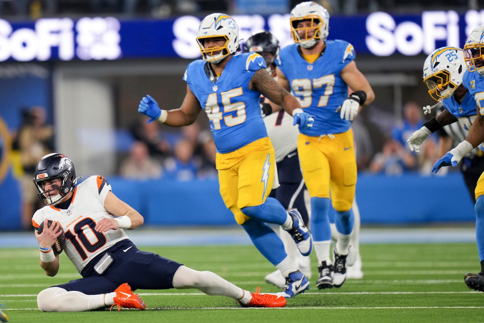 Denver Broncos quarterback Bo Nix (10) slides after gaining yards during the first half an NFL football game against the Los Angeles Chargers, Thursday, Dec. 19, 2024, in Inglewood, Calif. (AP Photo/Eric Thayer)