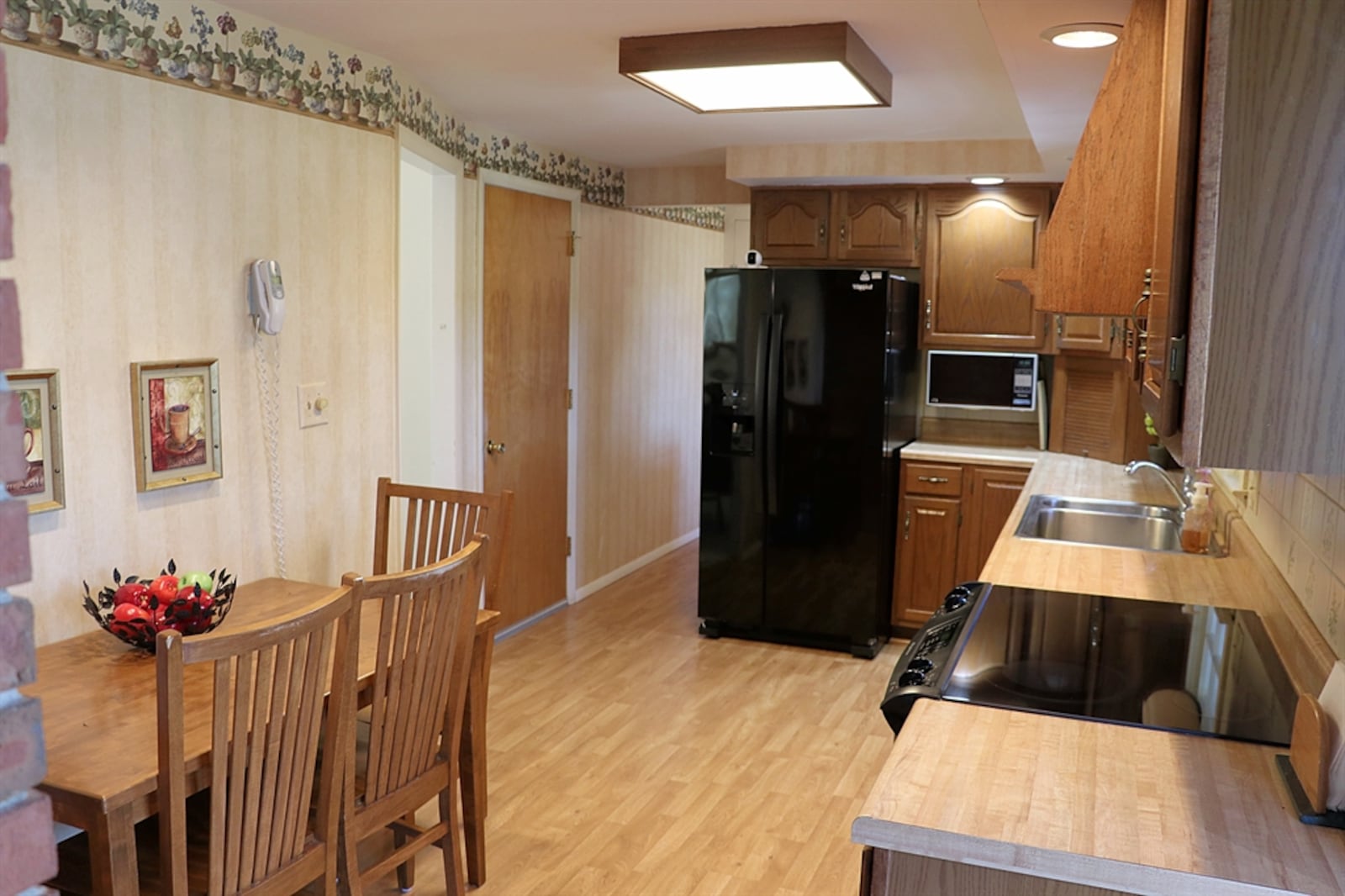 A narrow threshold leads from the dining room into the eat-in kitchen.