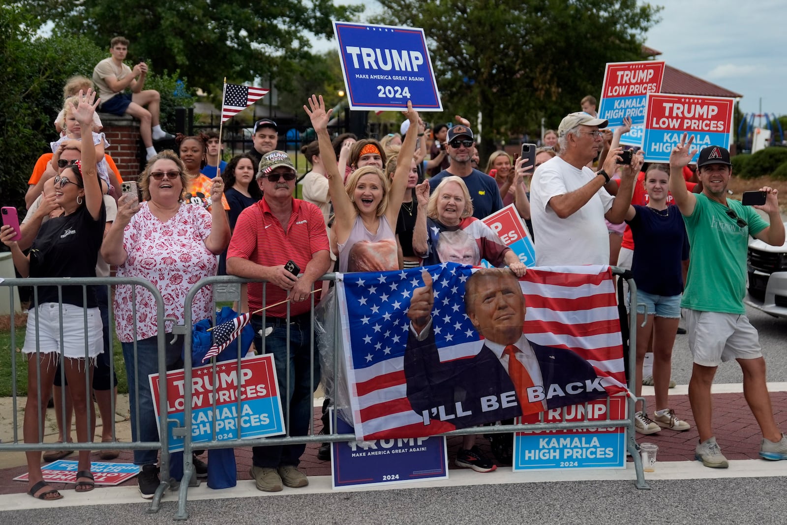 People line the road as Republican presidential nominee former President Donald Trump arrives to speak at a temporary relief shelter as he visits areas impacted by Hurricane Helene, Friday, Oct. 4, 2024, in Evans, Ga. (AP Photo/Evan Vucci)